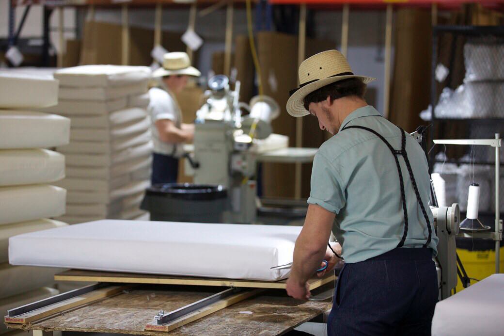 man sewing a mattress