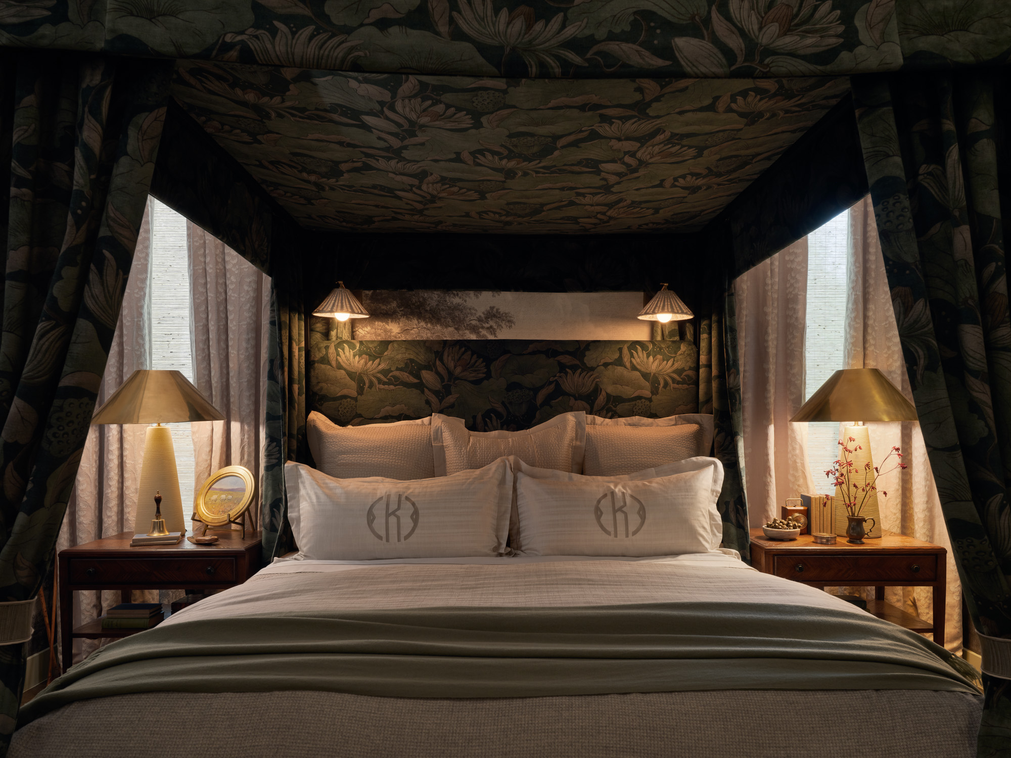 A four-poster king bed with green velvet drapery and Peacock Alley bedding