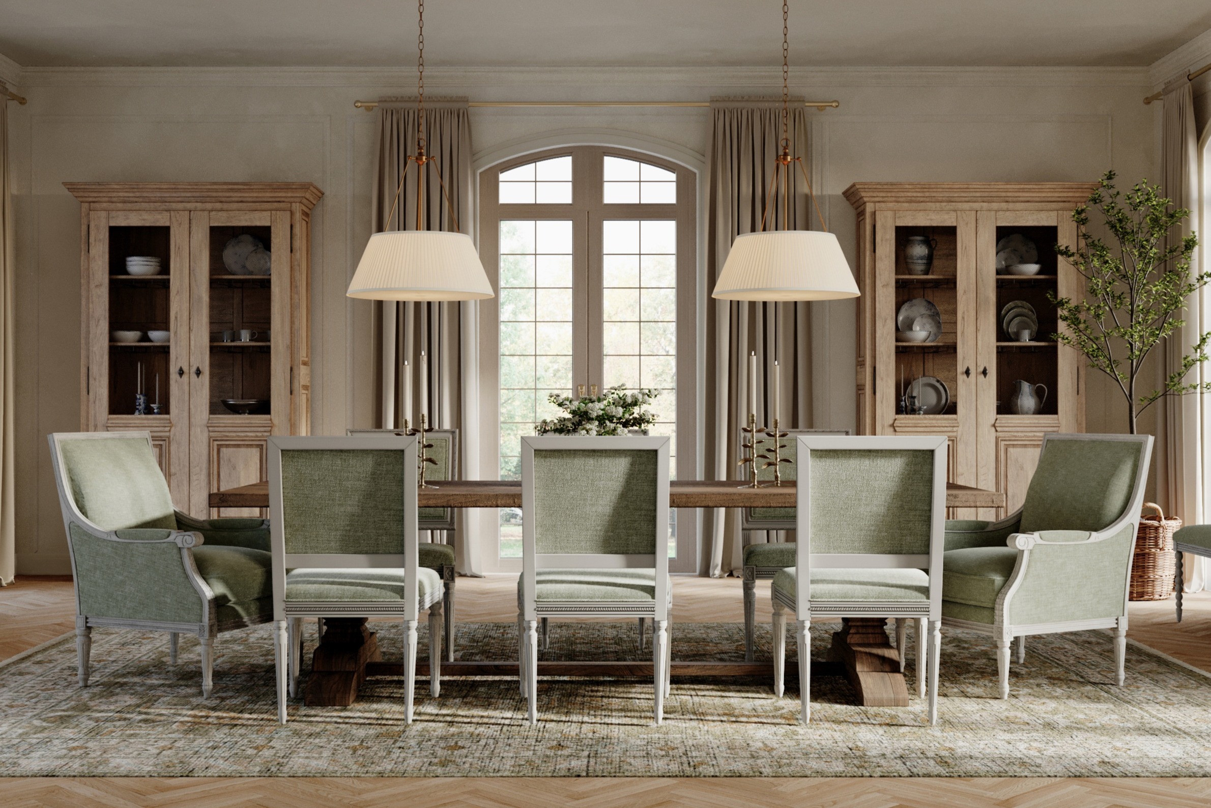 A warm dining room with green velvet side chairs, green velvet bergere chairs, a rectangular wood dining table, a green patterned rug, and two china cabinets