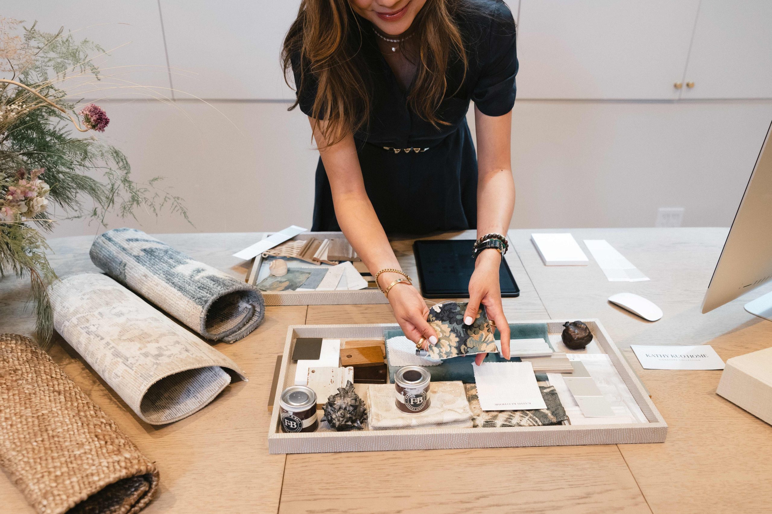 An interior designer reviews material samples and fabric swatches in her New York Design Showroom
