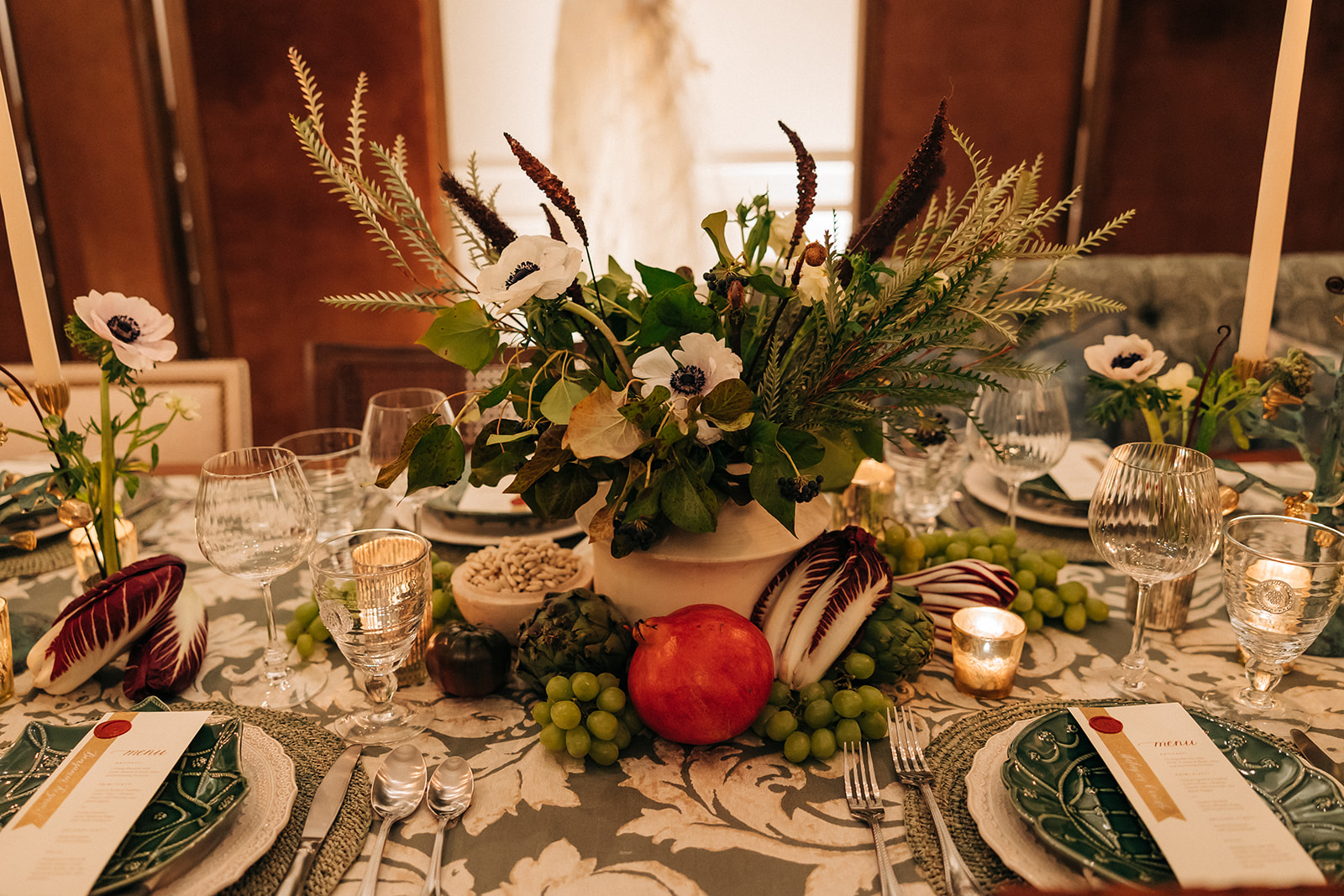 a floral centerpiece on the middle of a table setting