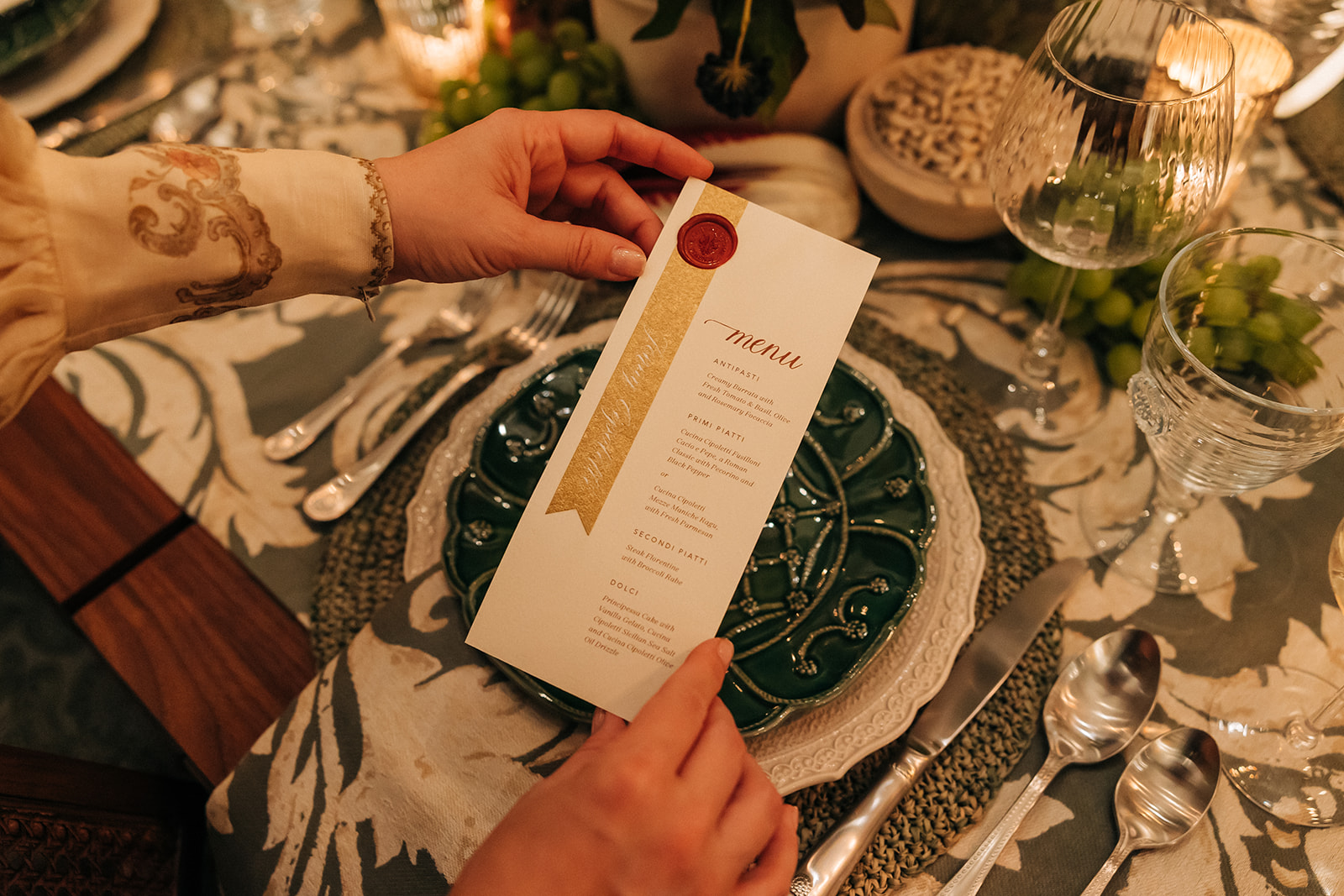 a dinner menu sits on top of layered place settings