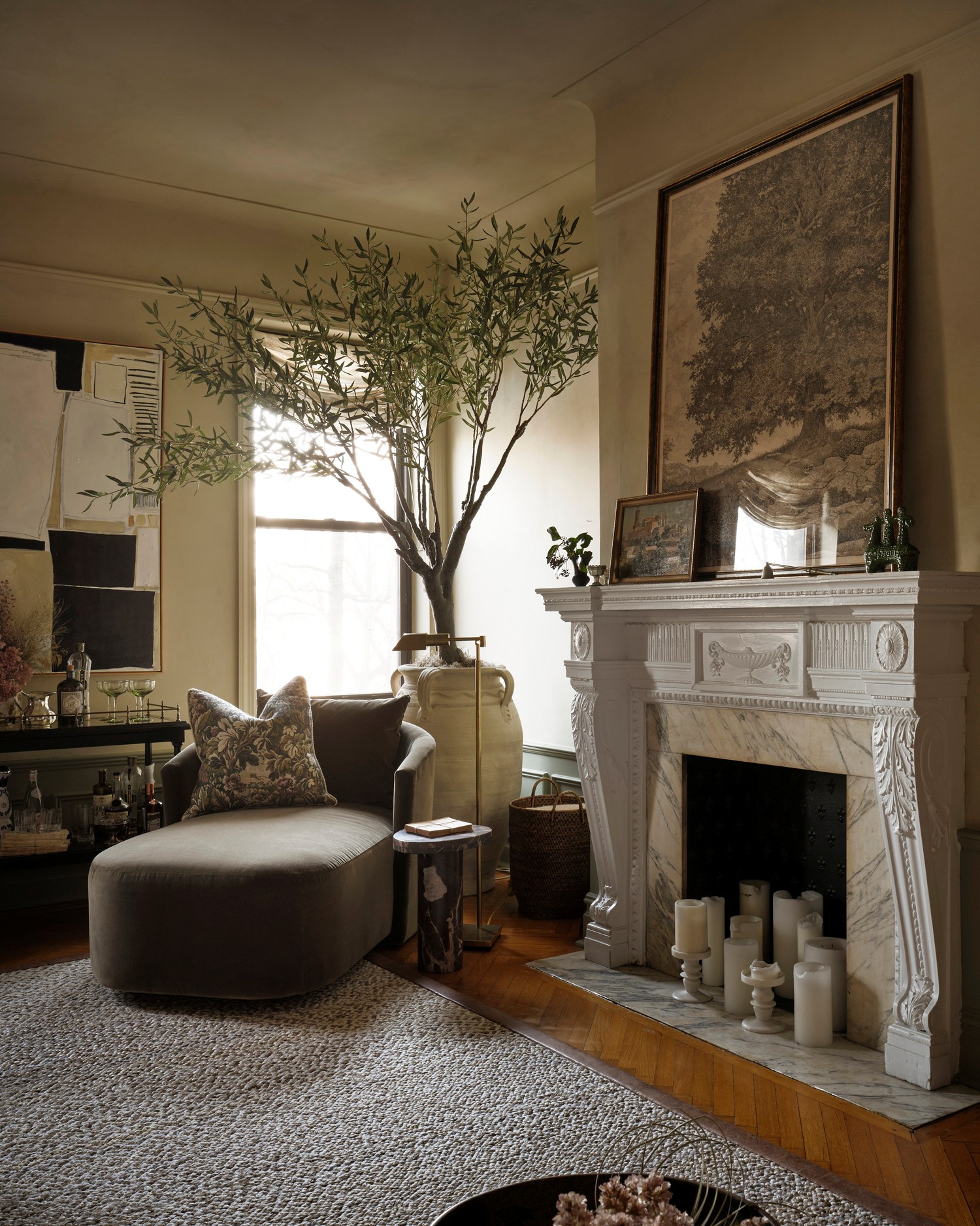 A green velvet chaise sits next to the fireplace in Kathy Kuo's New York living room