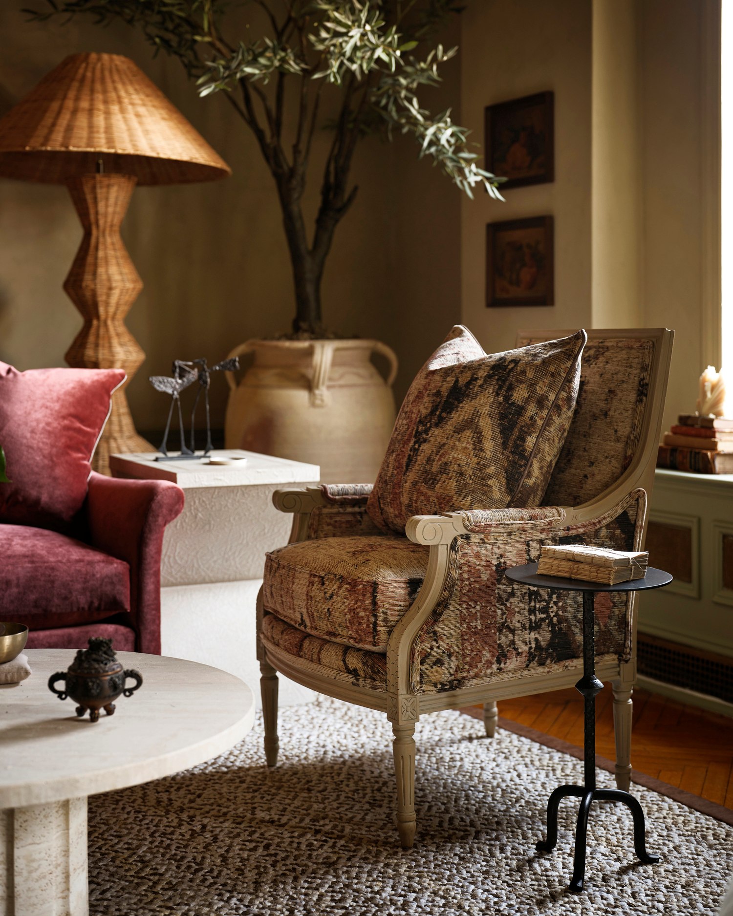 A kilim vintage bergere chair with a black iron drink table in Kathy Kuo's New York living room
