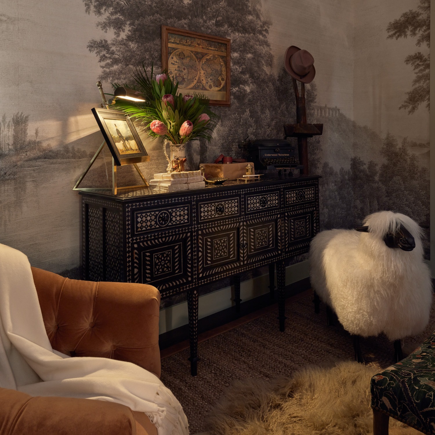 A mother-of-pearl and teak sideboard in a cozy primary bedroom
