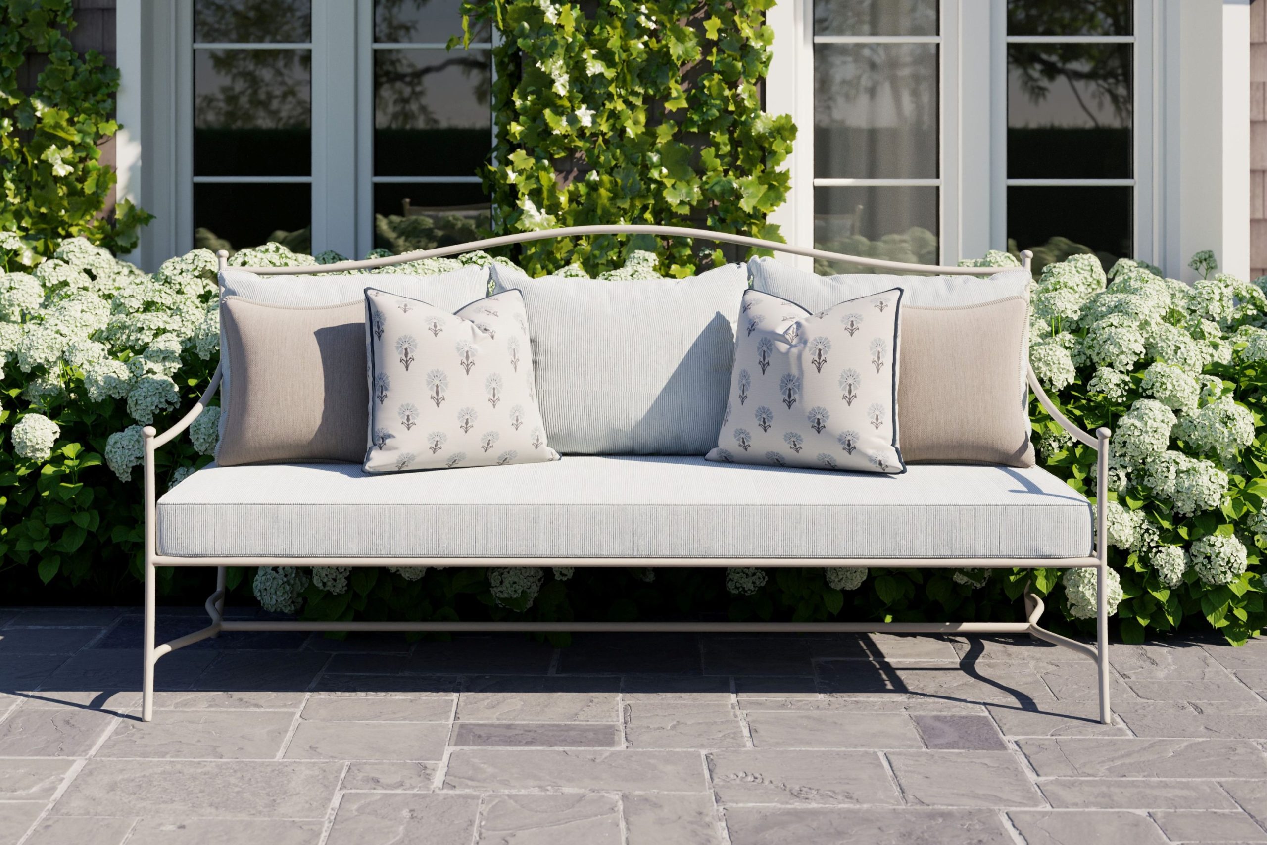 An outdoor sofa with striped sunbrella upholstery and Sunbrella throw pillows