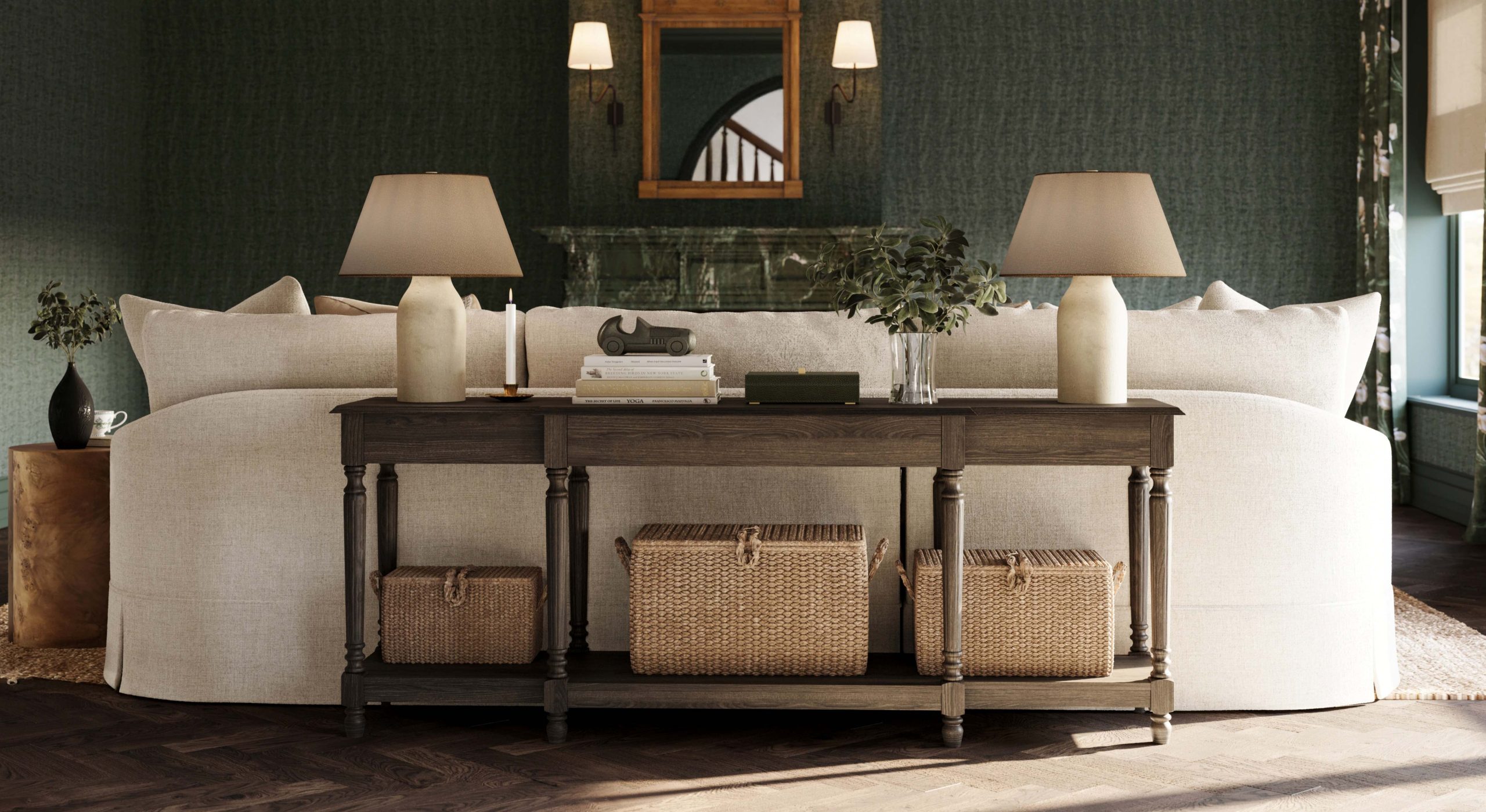 A cozy drawing room with a chaise sectional, oak console table, paper mache table lamps, and a green marble fireplace