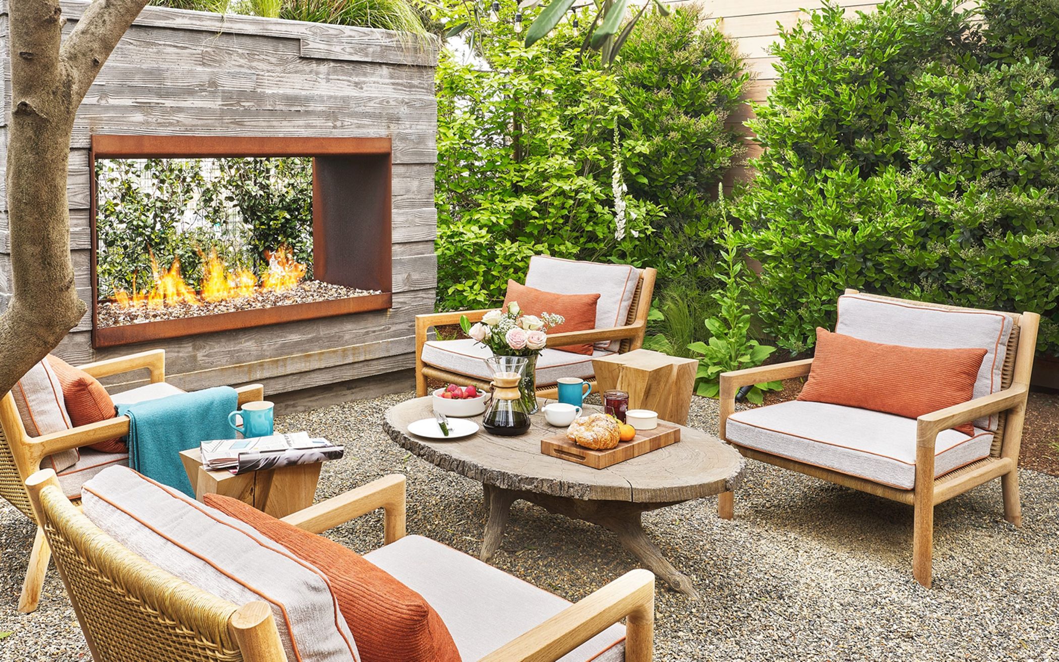 san francisco outdoor living space with a custom fireplace, lounge chairs, and an oval wood coffee table
