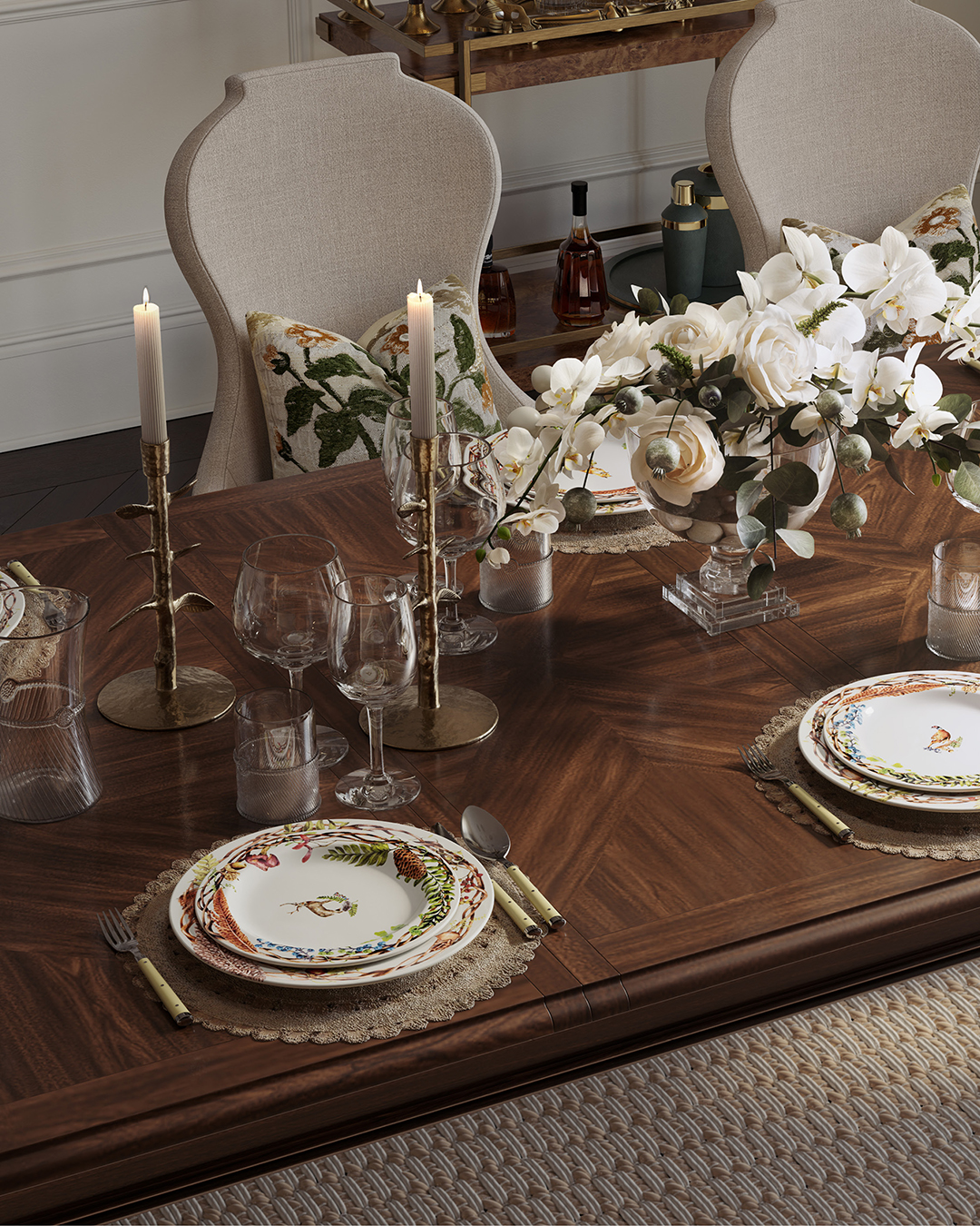 An extendable dining table is set for Thanksgiving dinner with chargers, plates, Juliska glasses, and tapered candles