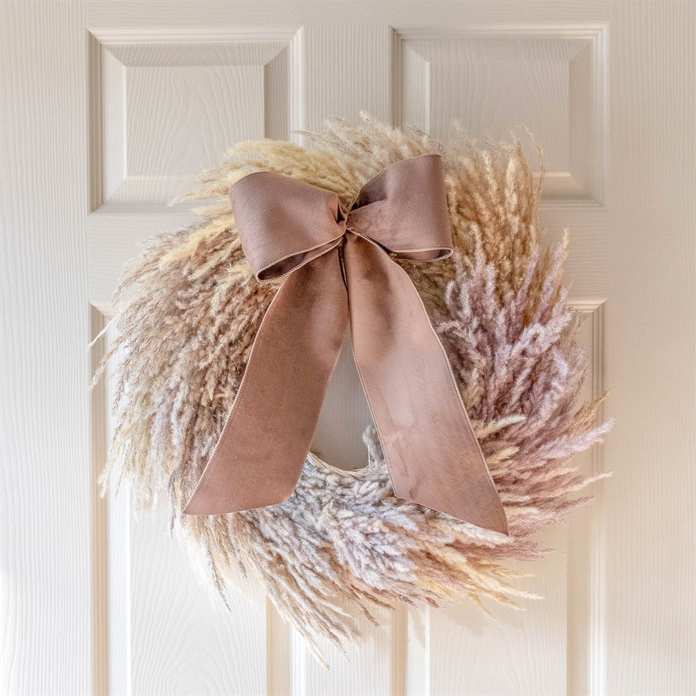 Pampas grass holiday wreath with a large pink velvet bow