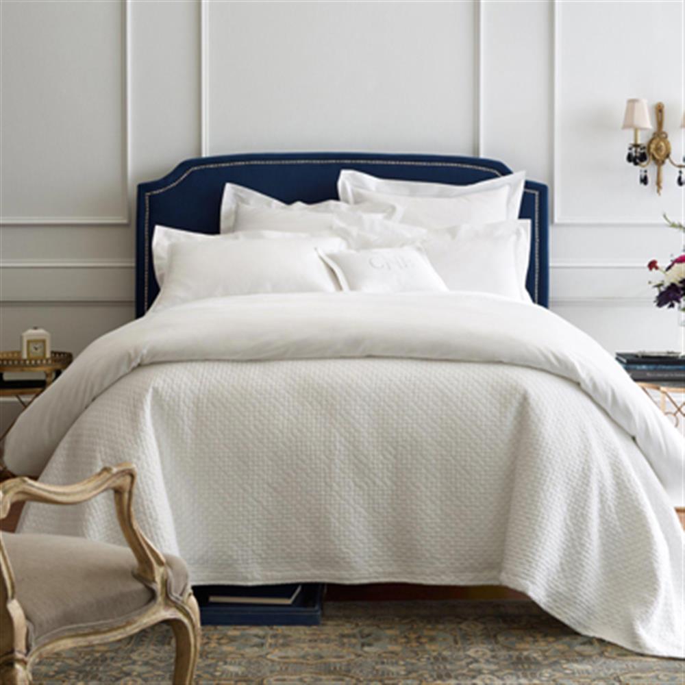 chic white bed with blue headboard