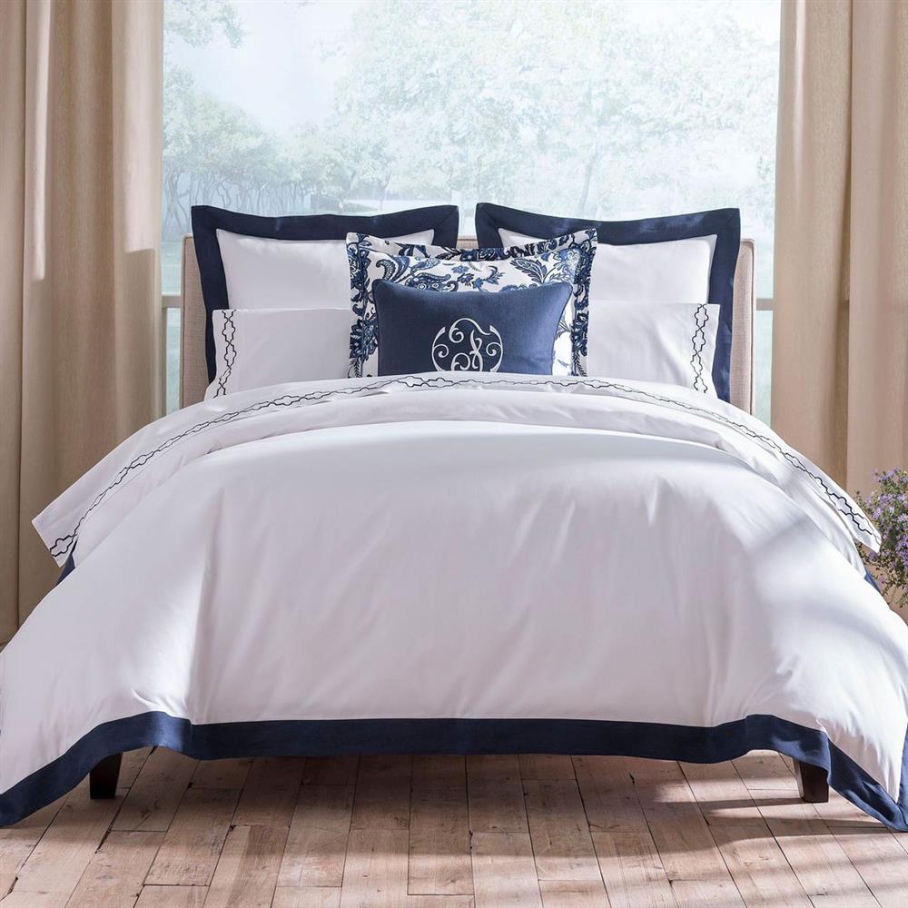 bed with white cover and blue pillows