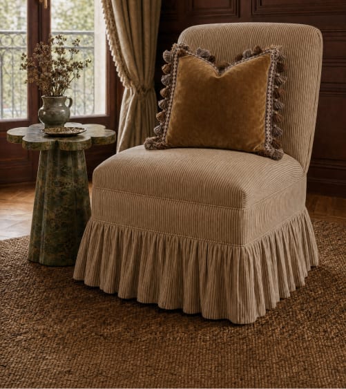 Skirted accent chair with a fringed pillow