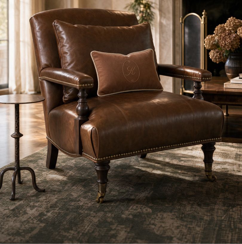 Tufted leather lounge chair with a monogrammed pillow