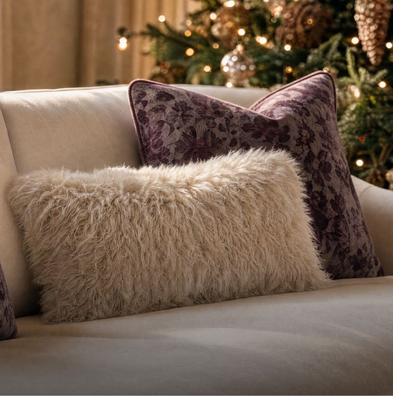 Faux fur and floral velvet pillows on a cream sofa