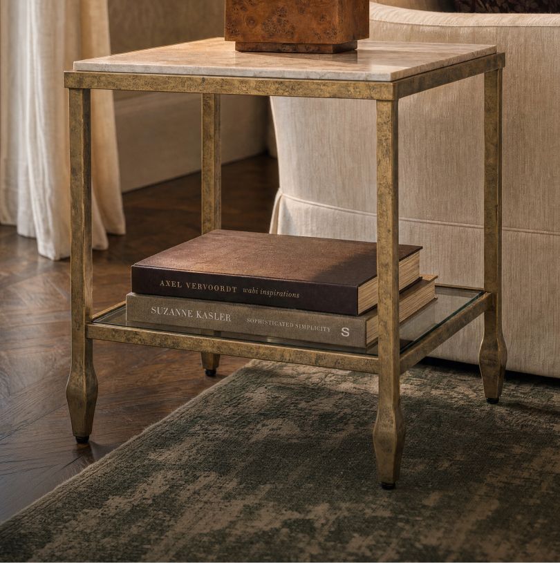 Brass and stone end table stacked with books